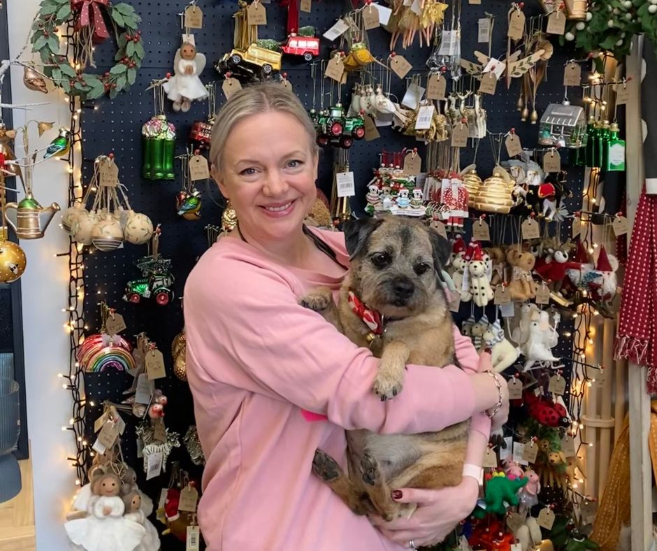 Steph Briggs in front of Christmas Display with Taitti the Border Terrier
