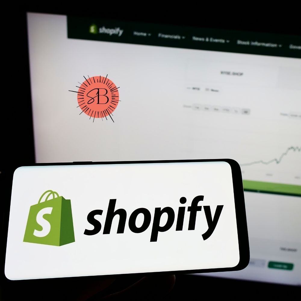 Shopify logo on a phone with desktop in background blurred