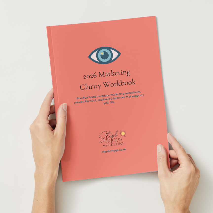 Person holding a '2026 Marketing Clarity Workbook' with a visible brand logo on a light background