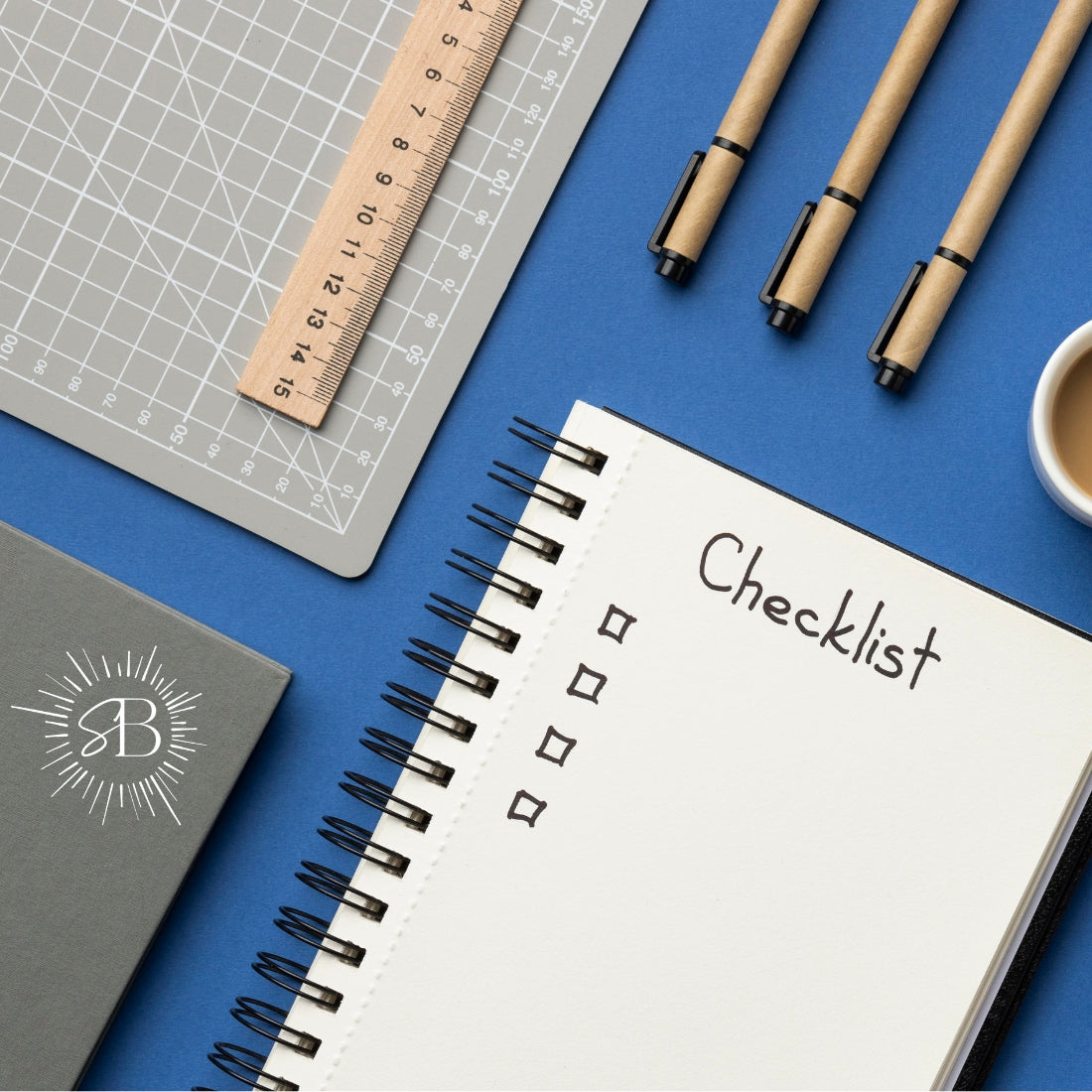 Notebook with 'Checklist' on a blue surface with stationery items