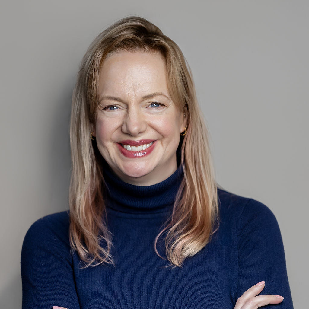 Woman wearing a blue sweater against a gray background