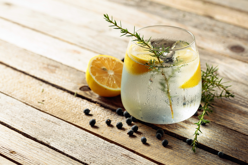 AI generated Gin & Tonic with herbs and lemon on wooden table